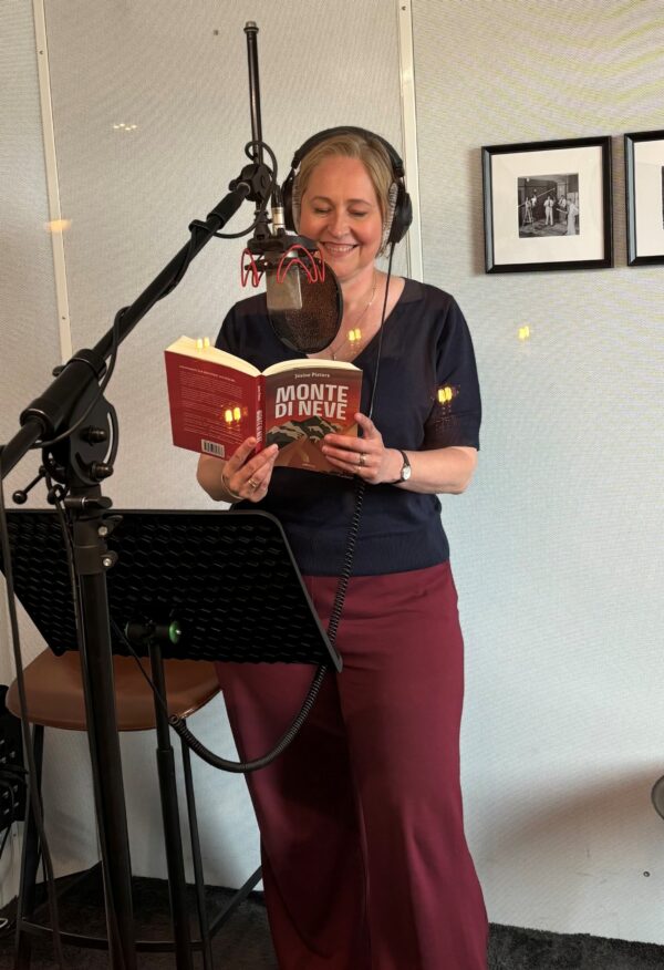 Josine Pieters als stemacteur in de opnamestudio, met microfoon en boek